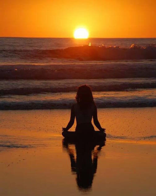 meditación en la puesta del sol en la playa